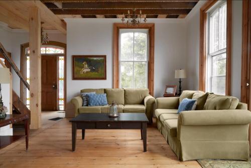 a living room with two couches and a coffee table at Hicks Holme - Beach Front Victorian in Waupoos