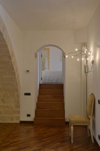 a hallway with a staircase with a chair and a stair case at Antica Civita Luxury Room in Matera