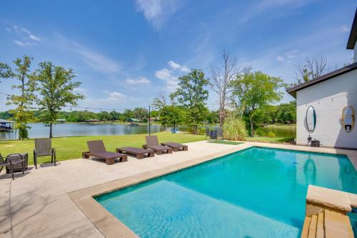 a swimming pool with lounge chairs next to a lake at On Cedar Creek Reservoir Malakoff Home with Pool! in Malakoff