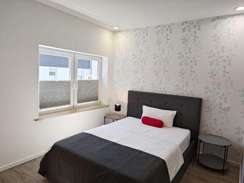 a bedroom with a bed with a red pillow on it at Minsu Hotel in Mülheim an der Ruhr