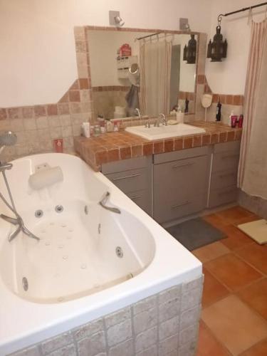 La salle de bains est pourvue d'une grande baignoire et d'un lavabo. dans l'établissement Mas Aubert, à Eyragues
