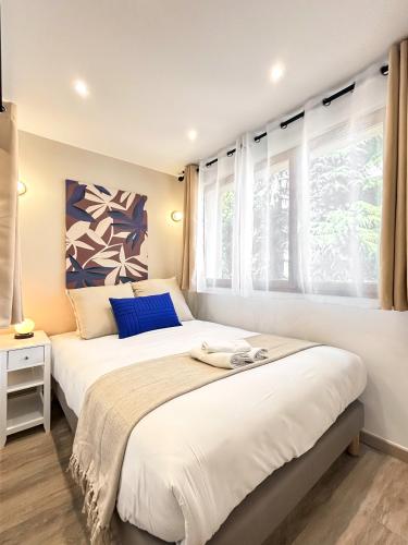 deux lits dans une chambre avec deux fenêtres dans l'établissement Hoche Apartment - PSG, à Le Pré-Saint-Gervais