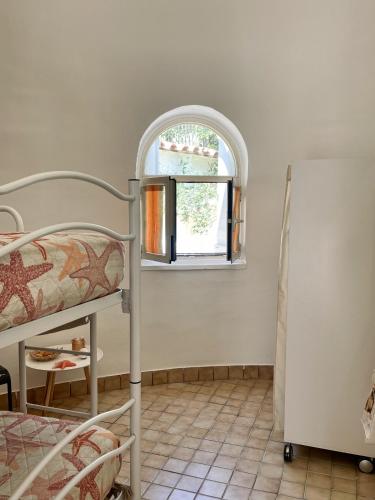a bedroom with a bunk bed and an arch window at Casa Vacanze Perla Marina in Marsala