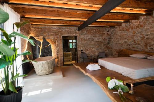 a bedroom with a bed in a brick wall at World Studio Sibiu in Sibiu