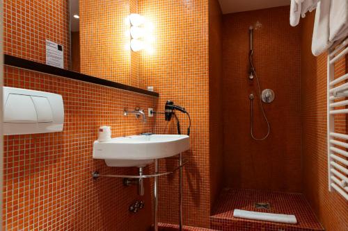 a bathroom with a sink and a shower at Hotel Burrhus in Vaison-la-Romaine