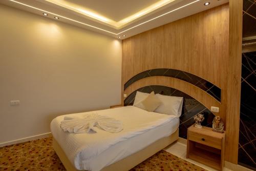 a bedroom with a bed with a wooden headboard at The Muse Pyramids INN in Cairo