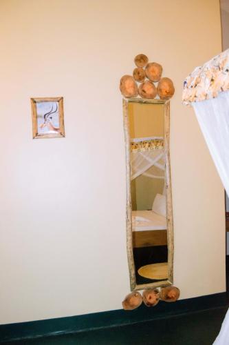 a mirror on a wall next to a bed at Kilimanjaro Scenic Homestay in Moshi