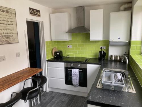a kitchen with a sink and a stove at Modernised 4bed stay-away-home in Runcorn sleeps 7 in Runcorn