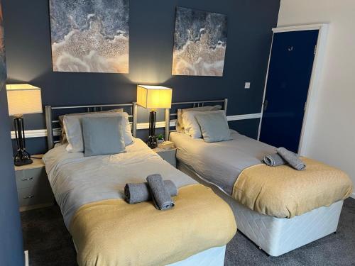 two beds in a room with blue walls at Modernised 4bed stay-away-home in Runcorn sleeps 7 in Runcorn