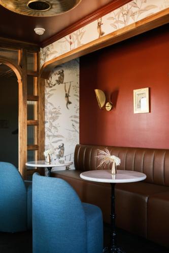 a restaurant with two tables and a leather couch at The Madison Hotel in Dallas