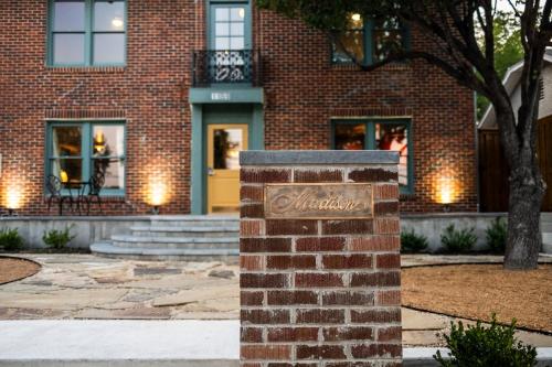 a brick sign in front of a brick building at The Madison Hotel in Dallas