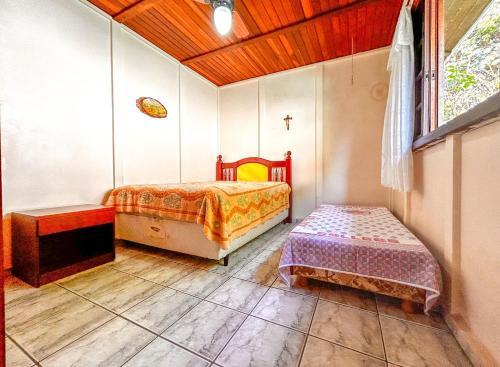 a bedroom with a bed and a table and a window at Chácara com piscina, churrasqueira, WiFi e quadra in Mairinque