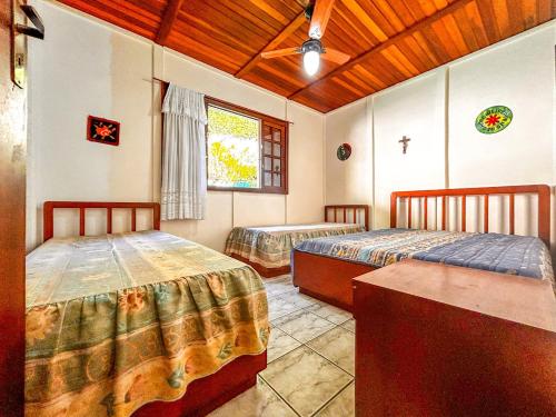 a bedroom with two beds and a window at Chácara com piscina, churrasqueira, WiFi e quadra in Mairinque