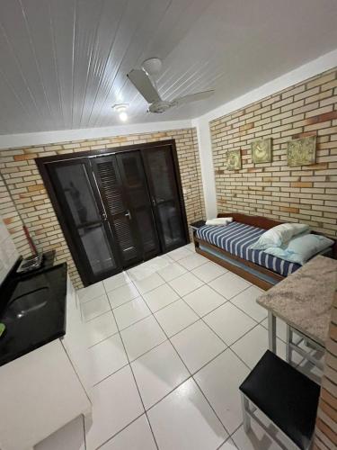a room with a bed and a brick wall at Pousada Ramo de Acácia in Bombinhas