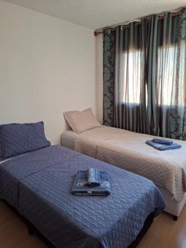 two beds in a room with a tray on the bed at Apartamento in Paranoá
