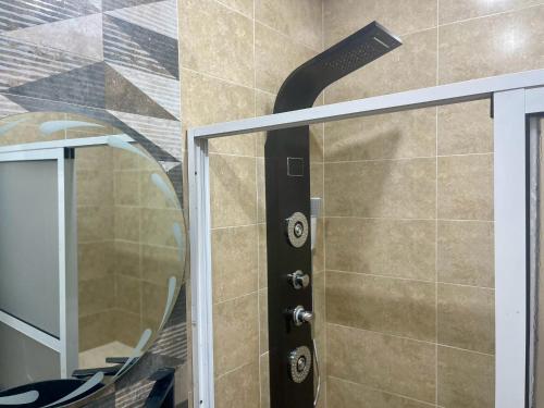 une douche avec une porte noire et un miroir dans l'établissement Appartement moderne bien equipe, à Tanger