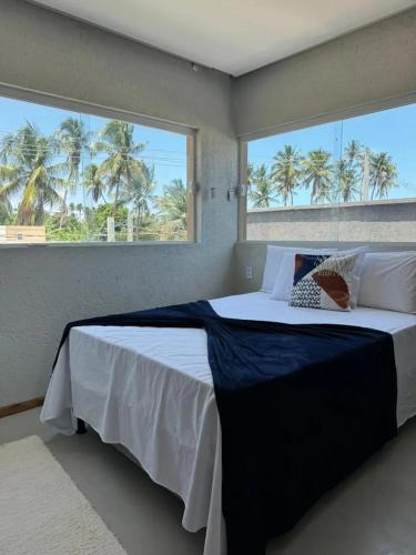 a bedroom with a large bed with a large window at Casa Garaguá - Porto de Pedras,AL - Patacho in Pôrto de Pedras