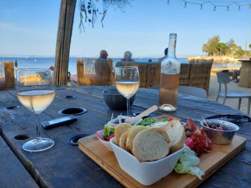 - une table avec une assiette de pain et des verres à vin dans l'établissement Le charme de la Venise provençale, à Martigues