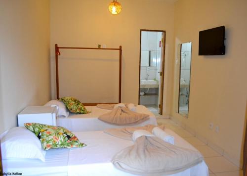 Dos camas en una habitación con espejo. en Pousada Jambo, en Trancoso