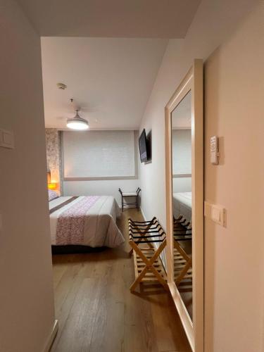 a small bedroom with a bed and a mirror at Apartamento Blois Deluxe Comfort in Rivas-Vaciamadrid