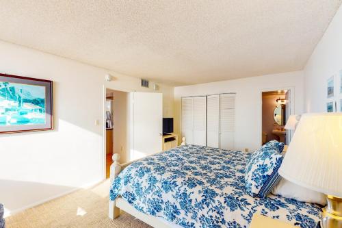 a bedroom with a bed with a blue and white bedspread at Sea Colony - 610 Dover House Rd. in Bethany Beach