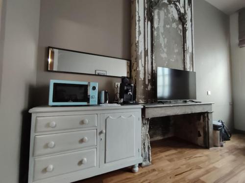 - une commode blanche avec un ordinateur portable en haut dans l'établissement Studio cosy quartier Chartrons étage 1, à Bordeaux