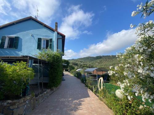 a blue house with a fence next to a road at Casa Elvira in Imperia