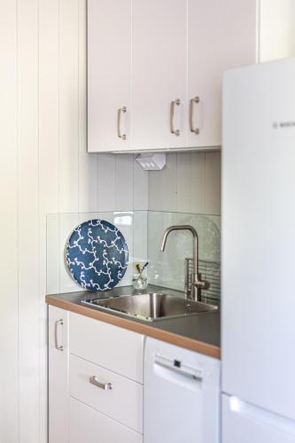 a kitchen with a sink and a white refrigerator at Gästhus Centralt i Småland in Fiskesjö