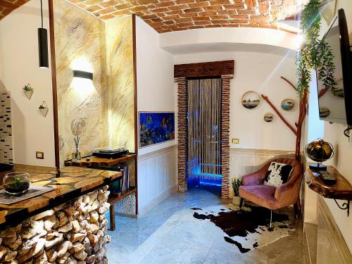 a living room with a fireplace and a chair at Suite Mediterraneo in Civitavecchia