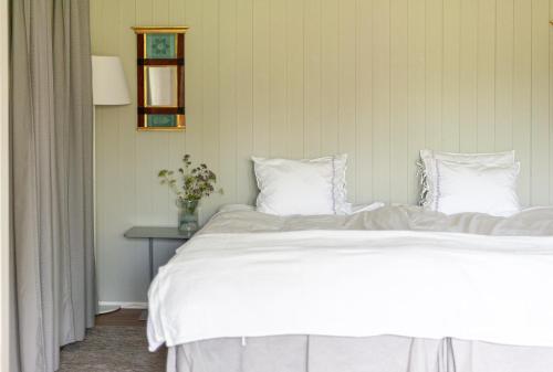 a bed with white sheets and pillows in a bedroom at Gästhus Centralt i Småland in Fiskesjö