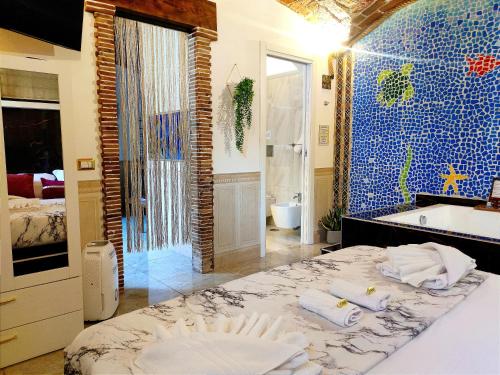 a bathroom with a large bed and a blue tiled wall at Suite Mediterraneo in Civitavecchia