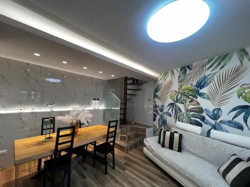 a dining room with a table and chairs and a couch at Very nice flat in Lerici 5 terre Villa Aurora in centro con parcheggio in Lerici