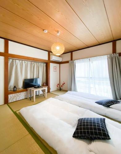 a bedroom with two large beds and a television at New Super Deals Now Available Direct Access to Akihabara Shinjuku and Disneyland in Tokyo