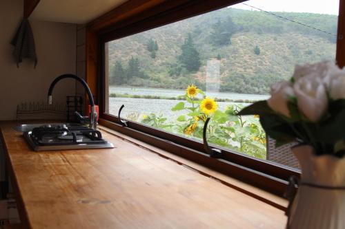 a kitchen window with a view of a lake at Cahuil lodge in Pichilemu