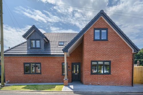 a red brick house with a black door at The Orchard in Telford