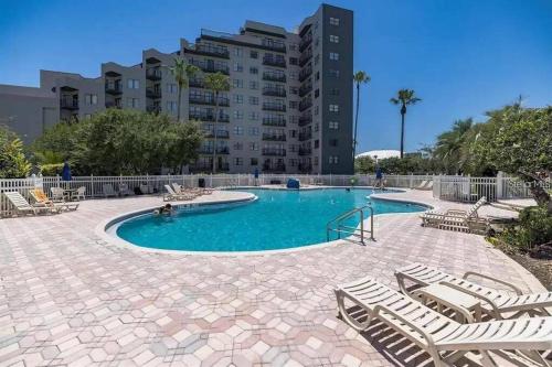 a swimming pool with lounge chairs and a building at Apartment near the EPIC park in Orlando