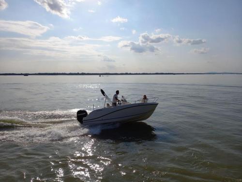 two people on a boat in the water at Delightful tiny river-view home in Šamorín