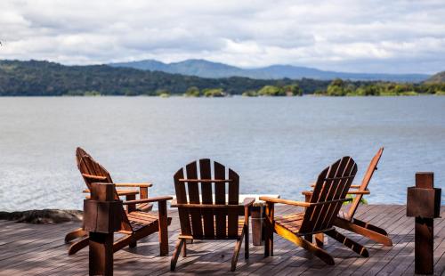 two chairs and a table on a dock by the water at Jicaro Island Lodge Member of the Cayuga Collection in Isletas de Granada