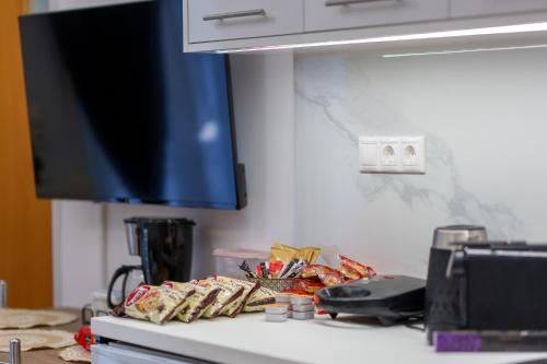 a counter top with a tv and some food at Blue Boutique Apts in Amoudara Herakliou