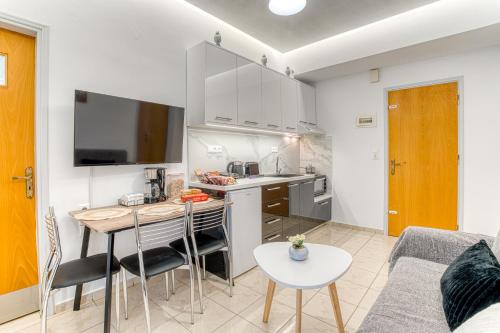 a kitchen and living room with a table and chairs at Blue Boutique Apts in Amoudara Herakliou