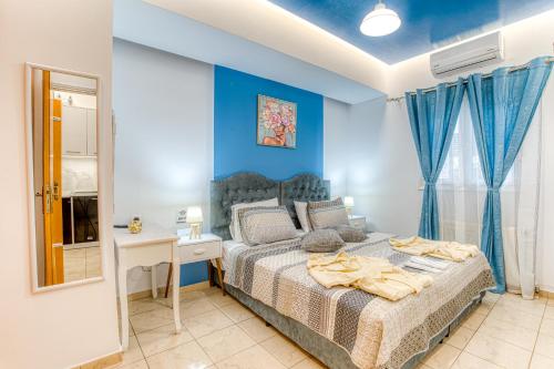 a bedroom with a bed and a desk and a mirror at Blue Boutique Apts in Amoudara Herakliou