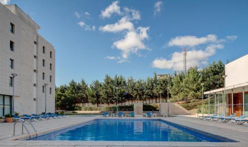 a swimming pool next to a building at VIP Executive Santa Iria Hotel in Santa Iria da Azóia