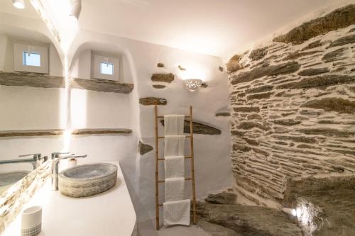 a bathroom with a stone wall and a sink at Lumina Kardiani in Kardiani