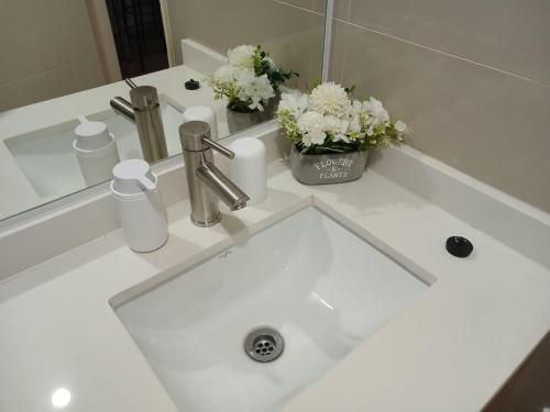 un lavabo de salle de bain blanc avec des fleurs et un miroir dans l'établissement Departamento Osorno centro, à Osorno