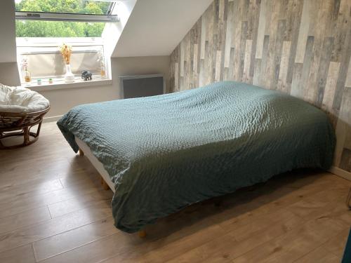 ein Schlafzimmer mit einem Bett mit einer grünen Bettdecke in der Unterkunft Près d'Etretat, joli appartement pour 4 personnes avec 2 chambres, vous pouvez me contacter sur Les gîtes de SoleilMapou in Bec-de-Mortagne