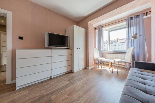 Una sala de estar con una cómoda con un televisor encima. en Grand Solen Apartment, en Gdansk