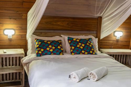 a bedroom with a bed with two towels on it at East Africa Safaris in Chizavane