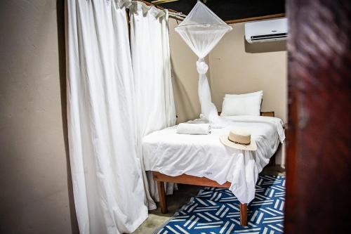 a bedroom with a bed with a hat on it at East Africa Safaris in Chizavane