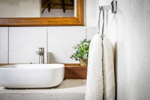 a bathroom with a sink and a white towel at East Africa Safaris in Chizavane