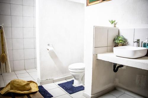 a bathroom with a white toilet and a sink at East Africa Safaris in Chizavane